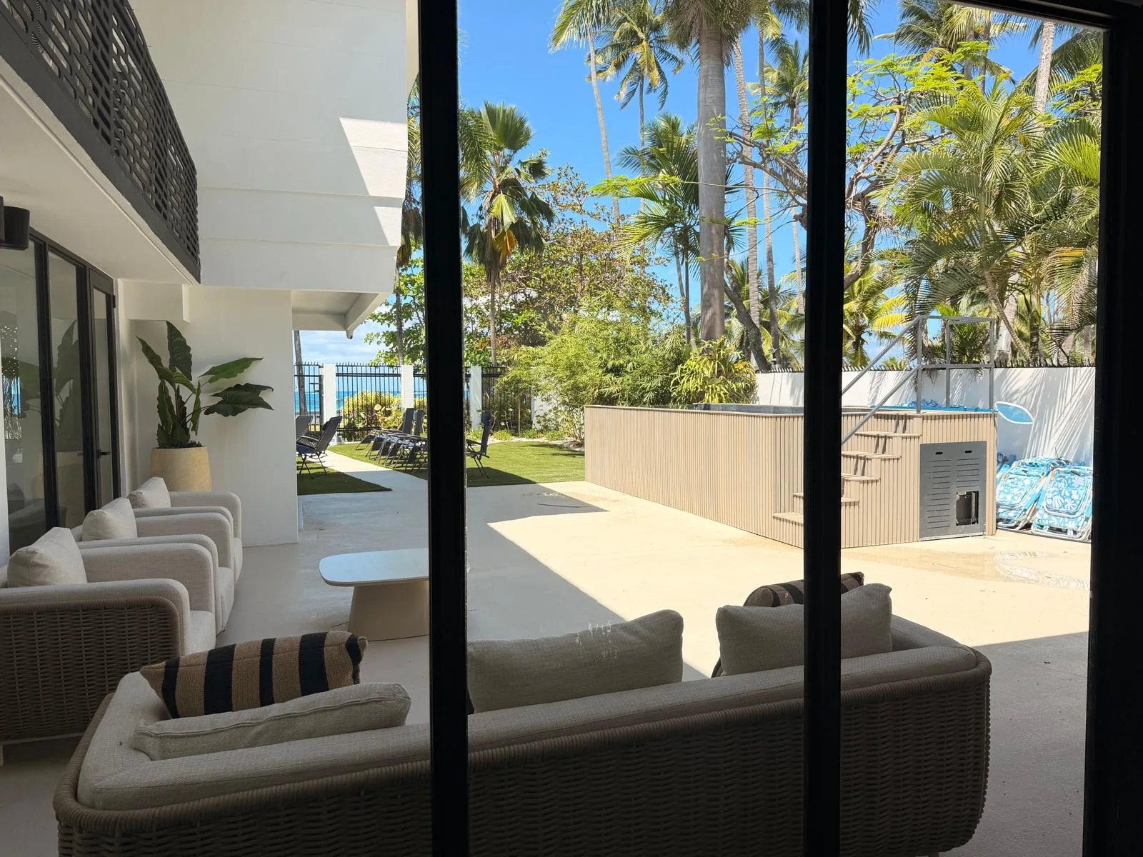 La piscina, las palmas y el mar al fondo