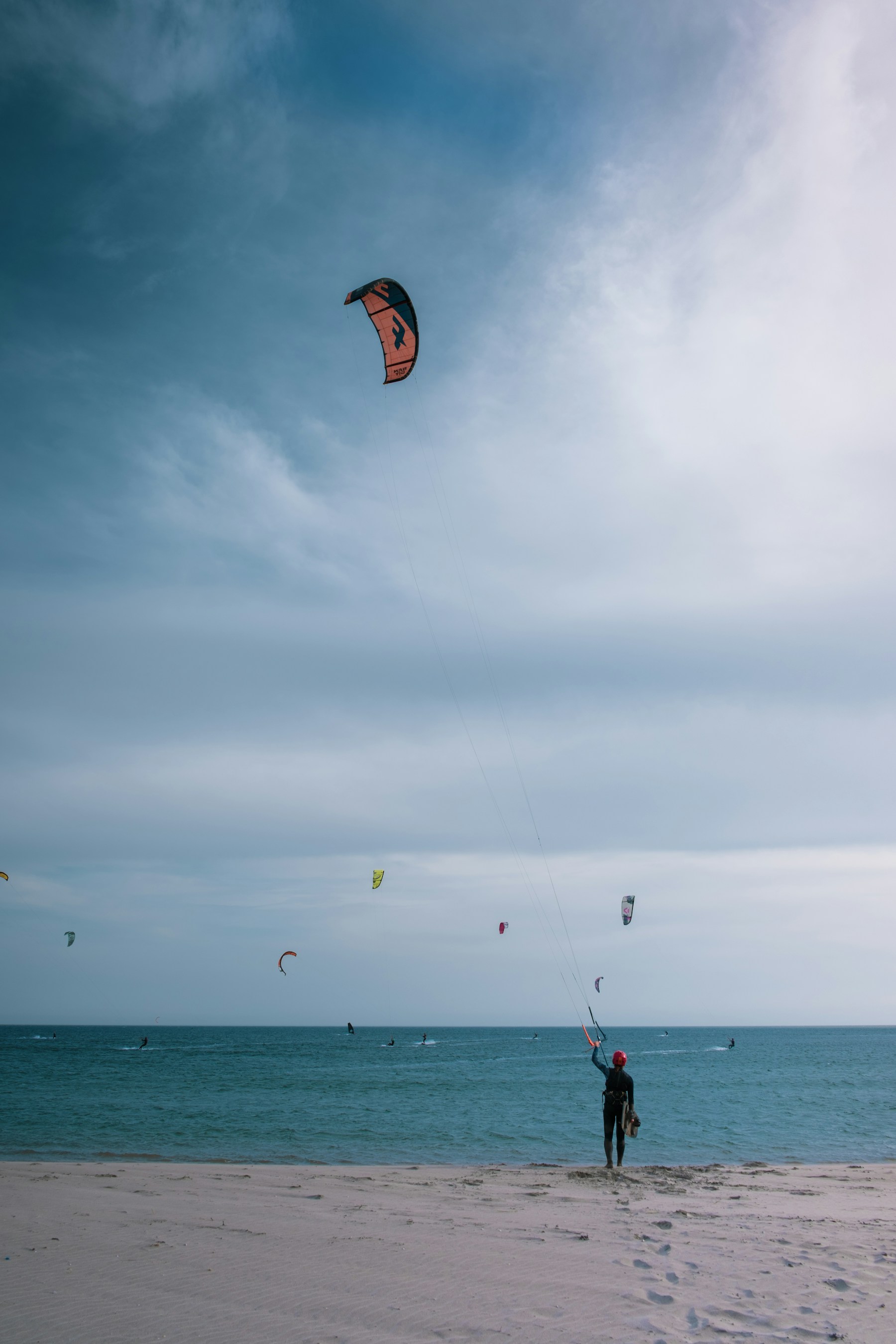 Kitesurfista lanzando su cometa en la playa