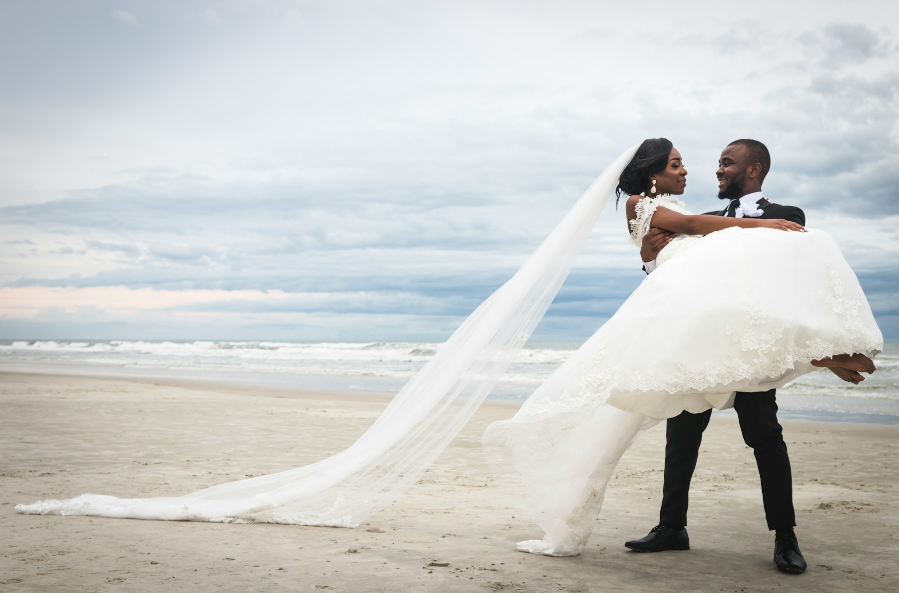 Bride in a long veil at the water's edge