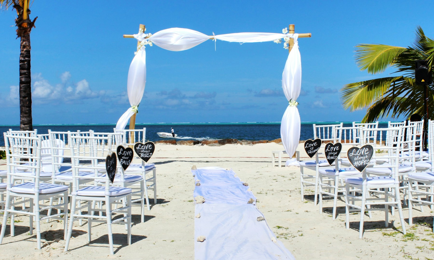 Beach wedding ceremony with white chairs and turquoise ocean view